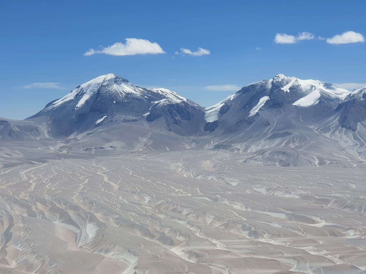 Twin snow-capped Andean peaks rising from the Atacama altiplano